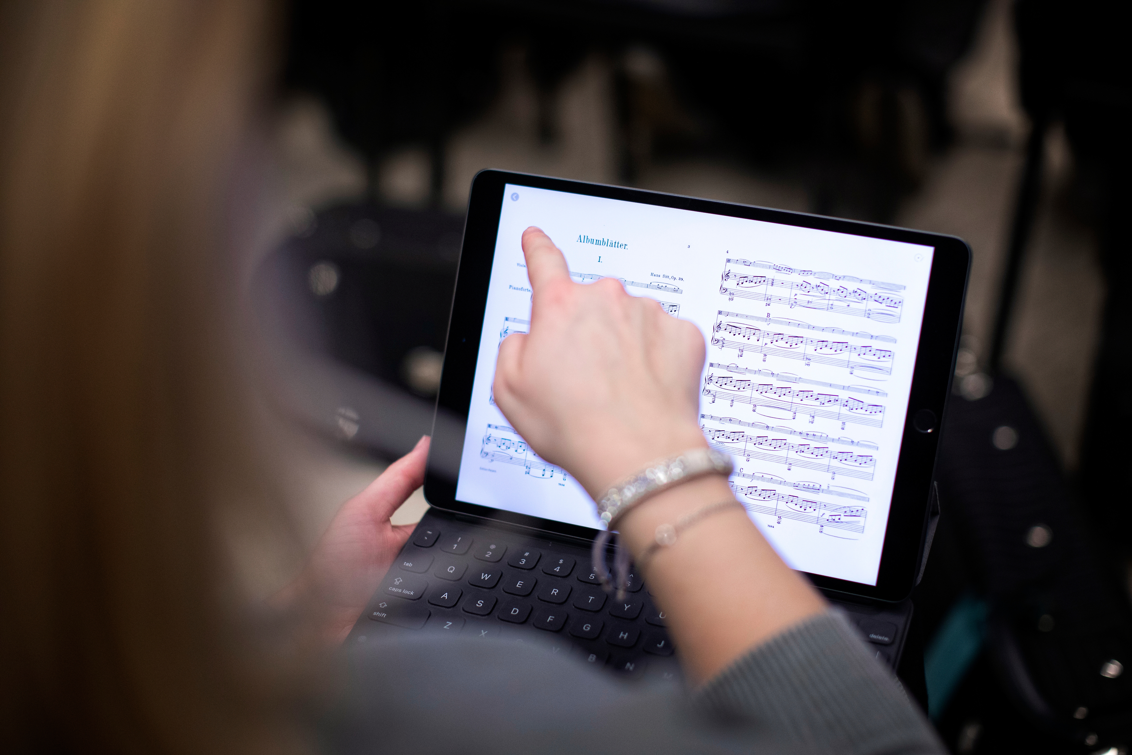student pointing to music on ipad