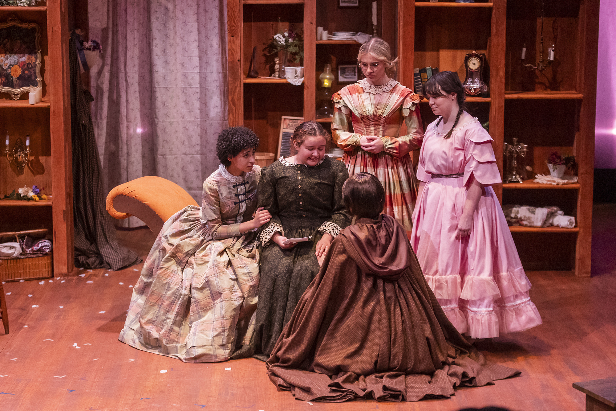 five women on stage in period dresses