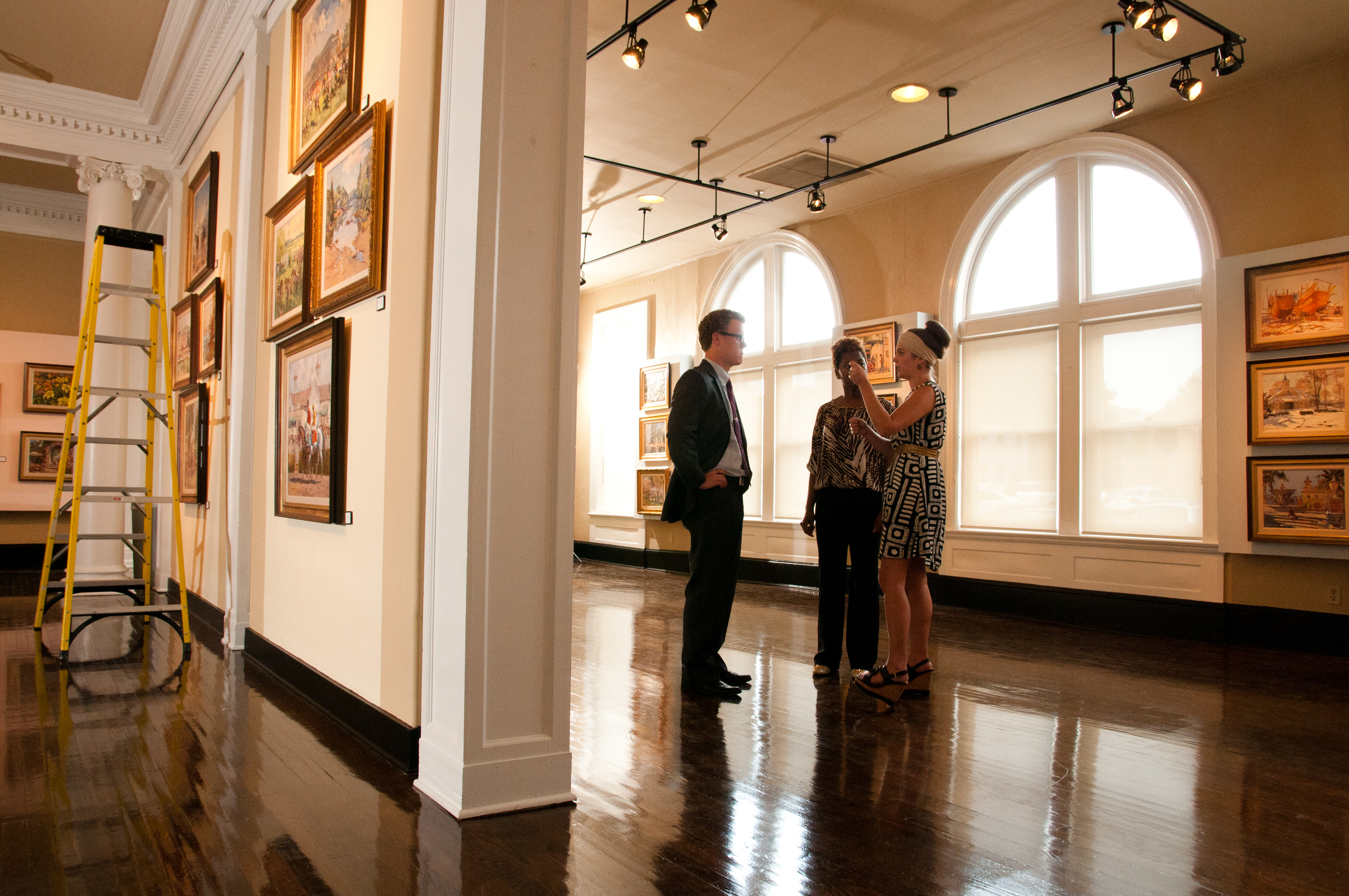 three people talking in a gallery