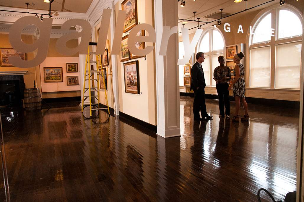 three people talking in a gallery