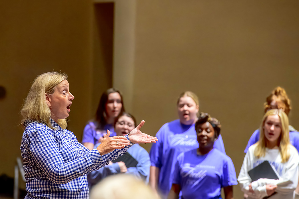 Lori Hetzel conducting student vocalists