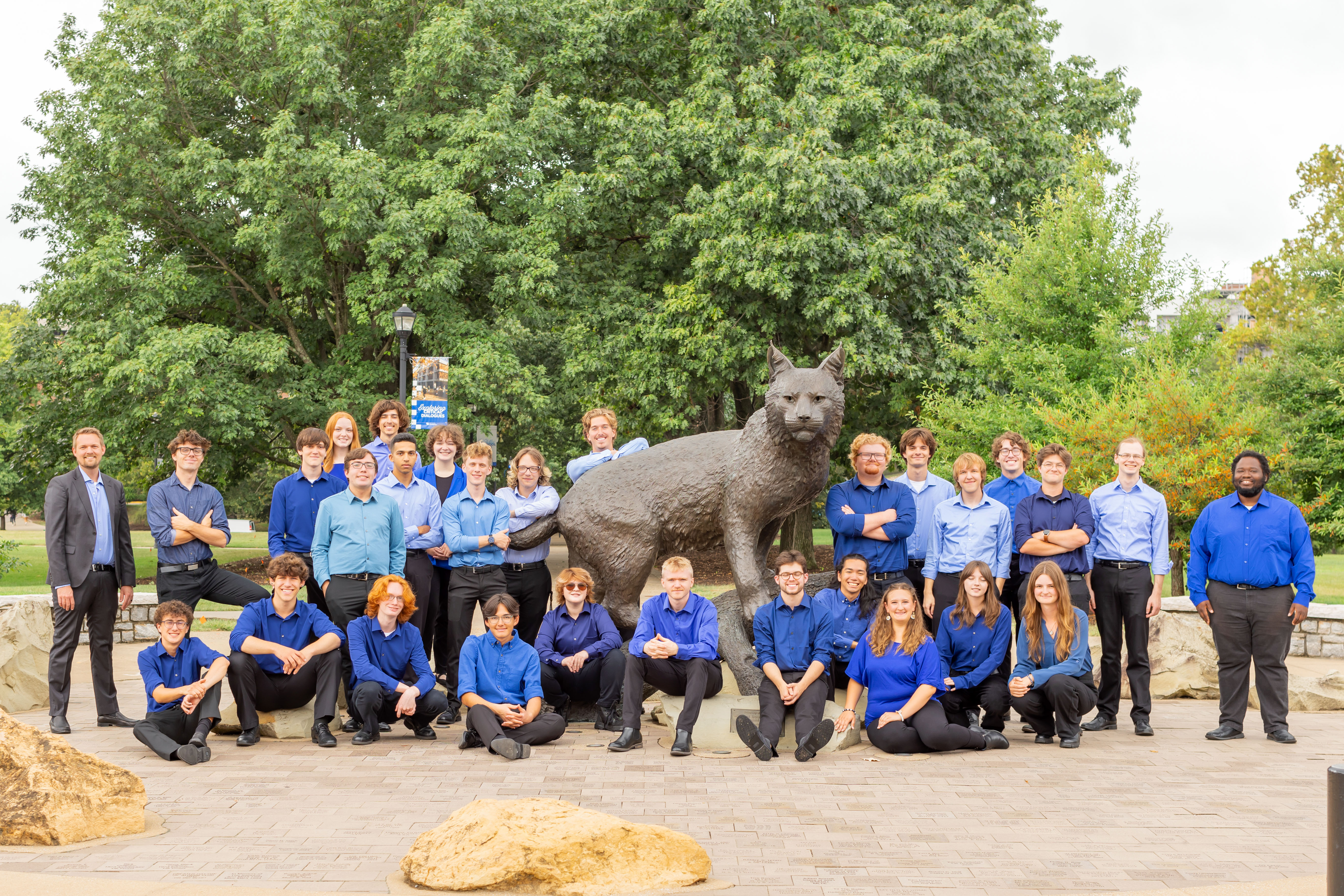 percussion students posed with statue of bowman the wildcat