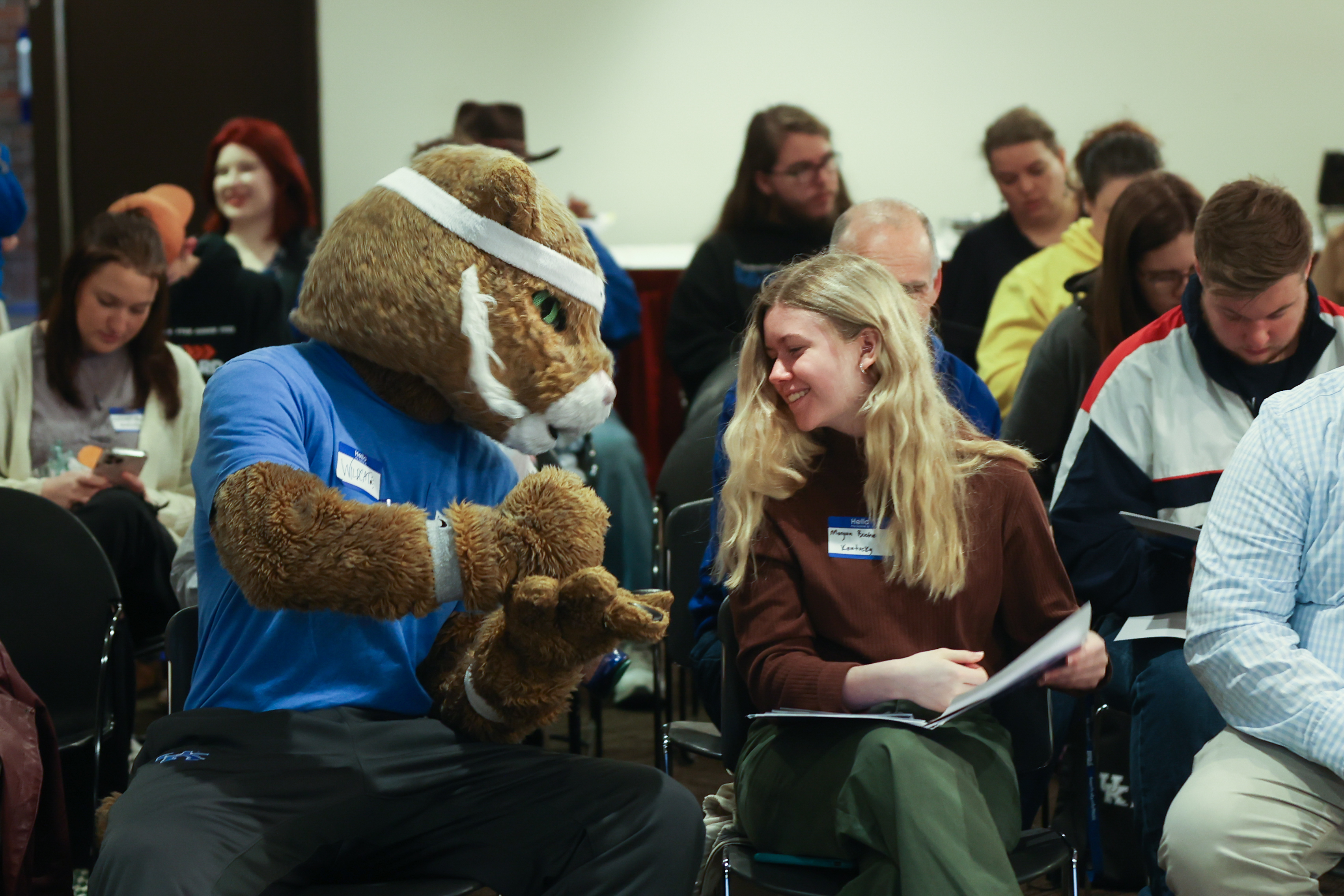 wildcat mascot and student sitting and looking at eacher