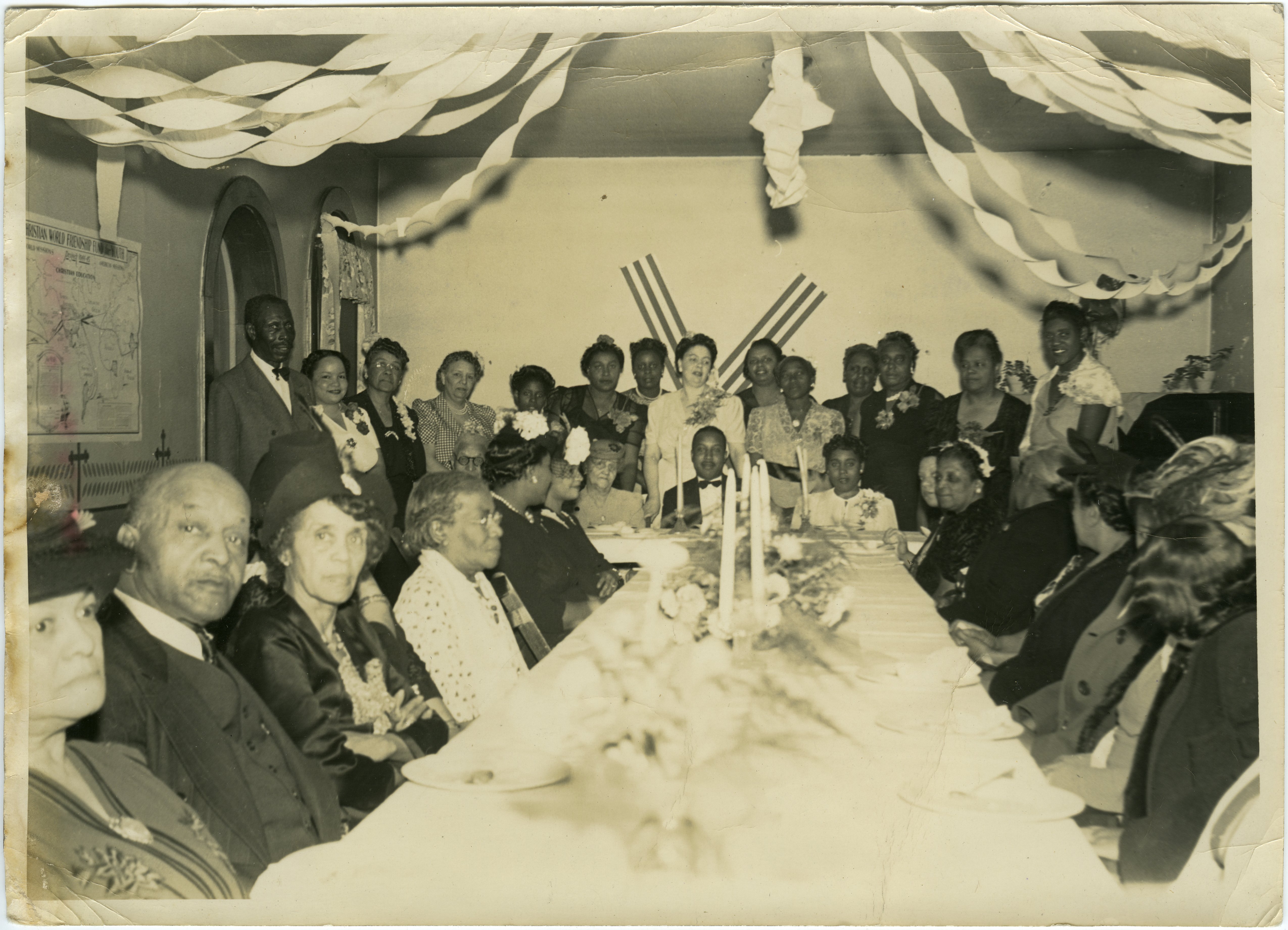 Group of African Americans sitting at a table including William Henry Fouse (1868-1944), Elizabeth Beatrice Cooke Fouse (1875-1952), Pastor of East Second Street Christian Church of Lexington, Kentucky Elder R.L. Saunders, and Emma W. Saunders