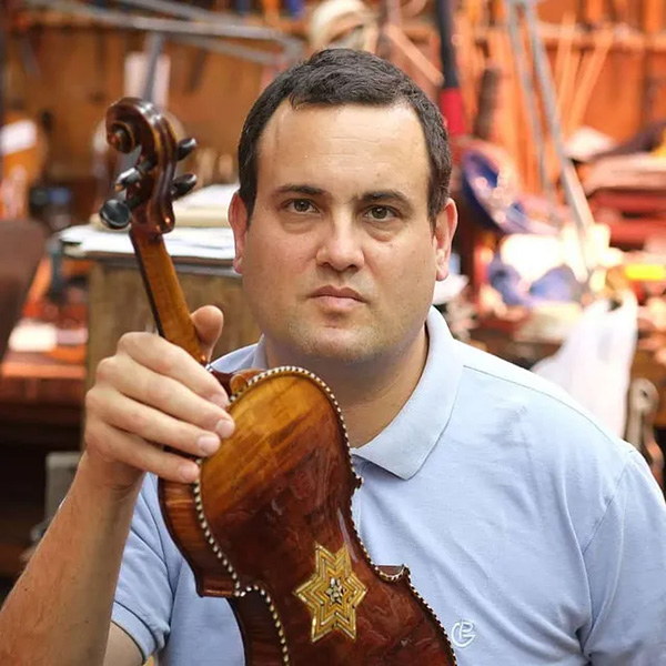 Avshi Weinstein holds a restored violin