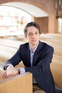 Portrait of Christina Snyder sitting in a brightly lit pew.