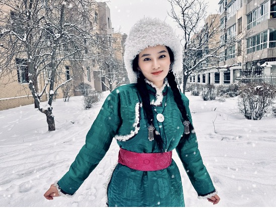 Portrait of Lotus Ai dressed in traditional clothing with a large fur hat out in a snowy city.