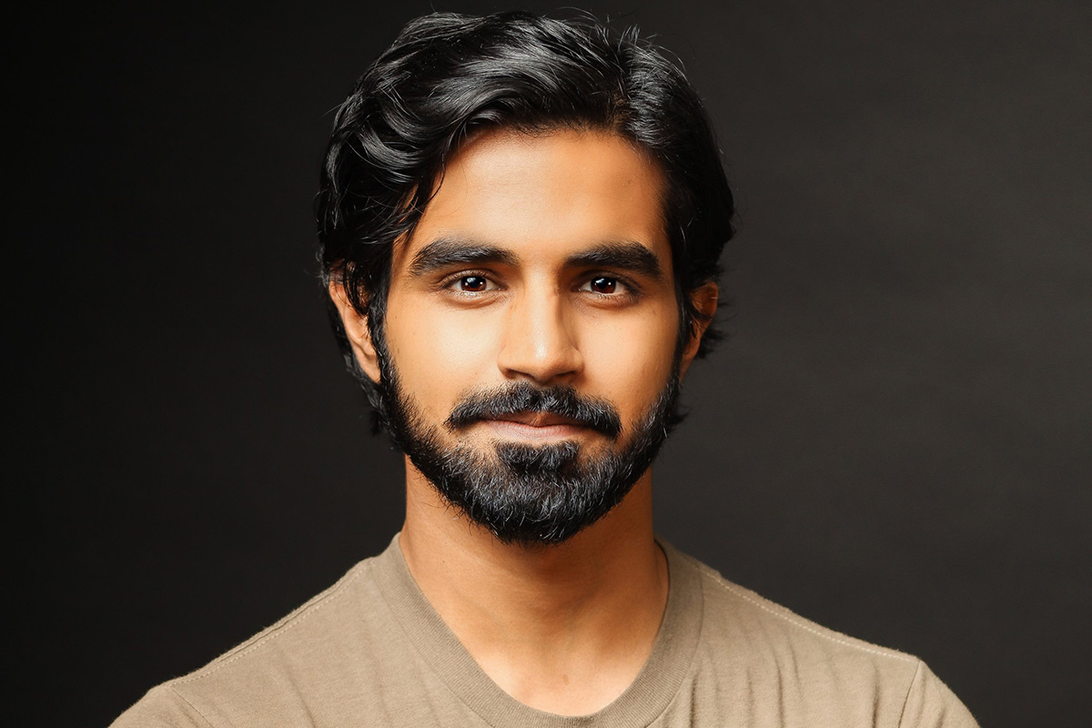 Headshot of Taha Mandviwala, wearing a tan shirt