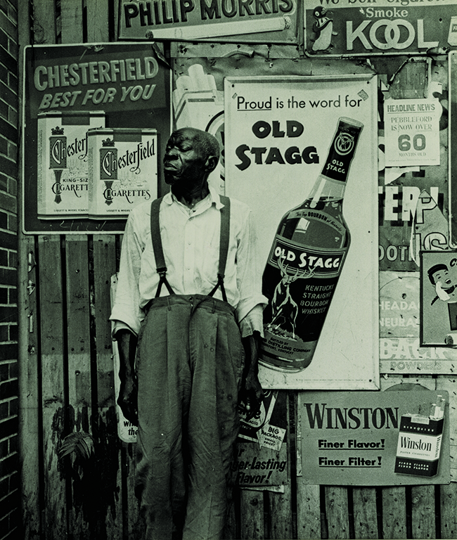 man standing next to sign of whiskey bottle