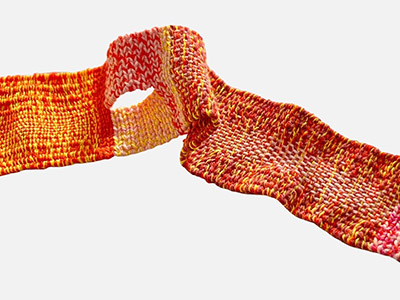 A thin belt woven from bright warm red, yellow, and pink yarns.