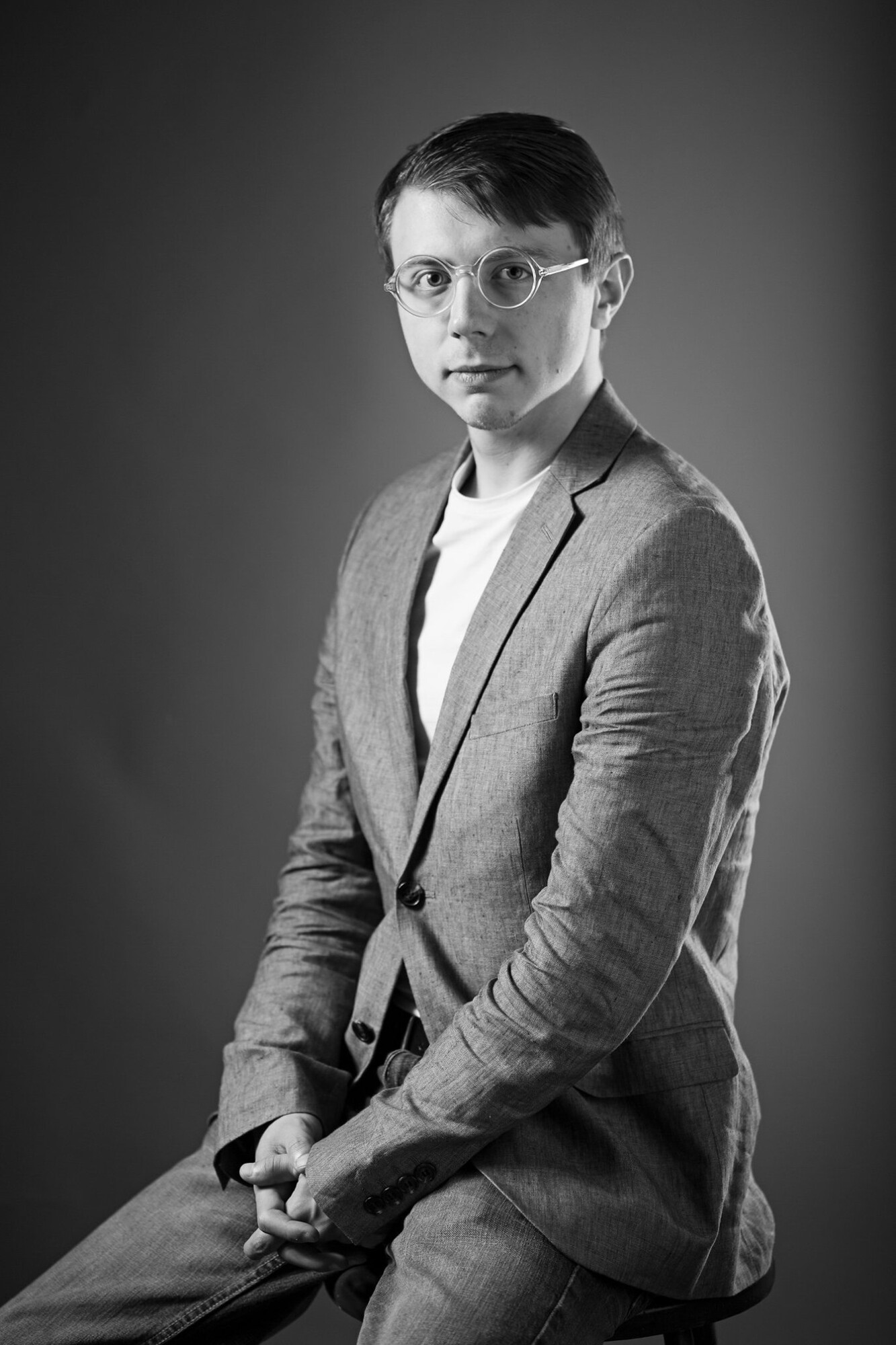 Headshot on Treyton Blackburn, black and white, seated with a suit on.