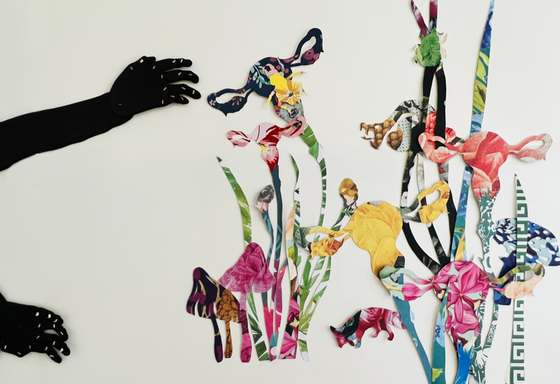 Detail of work by Ivy Johnson Fleming featuring flowers on a white background with hands in silhouette.