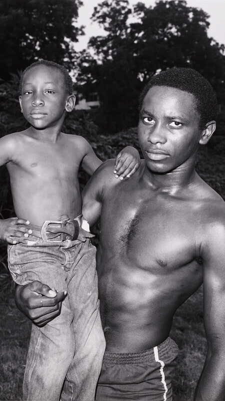 Detail of Baldwin Lee's photograph UNTITLED, VICKSBURG, MISSISSIPPI, 1984, showing black and white image of man holding a young boy.
