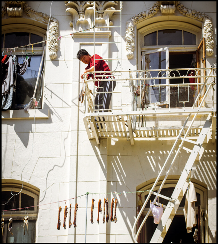 person on balcony with laundry on line