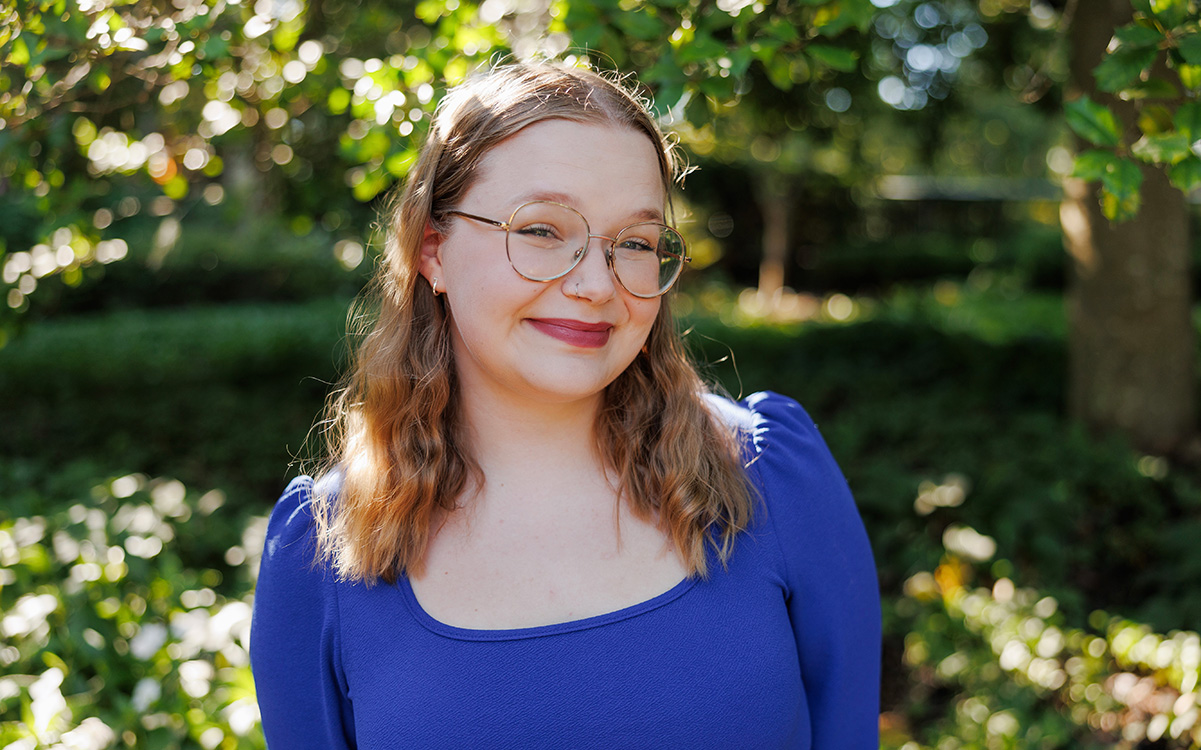 elizabeth watson smiling at camera with blurred trees background