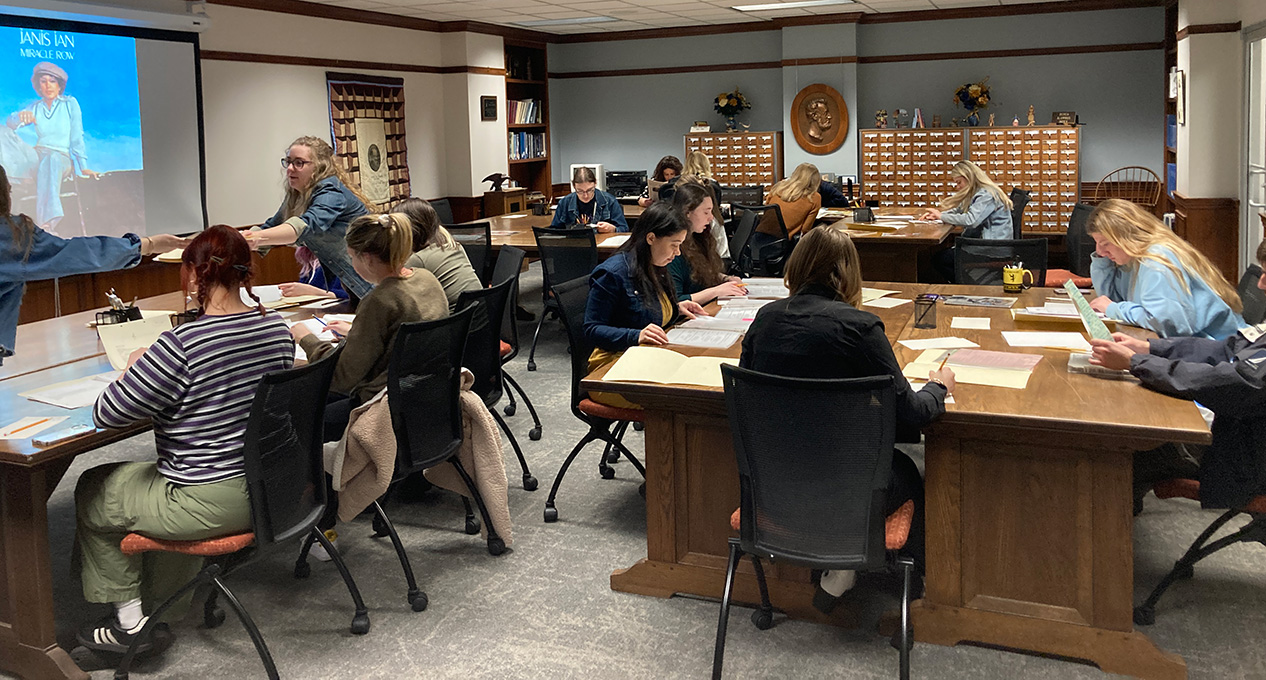 students at tables reading archives