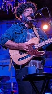 Colin Cutler onstage playing a guitar 