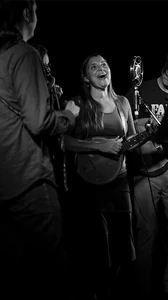 Black and white image of CornMaiz performing onstage holding instruments