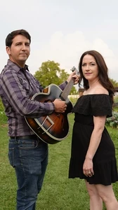 Rose and Vine, the duo of Andy Duckworth and Stephanie Jeter in a field with their instruments