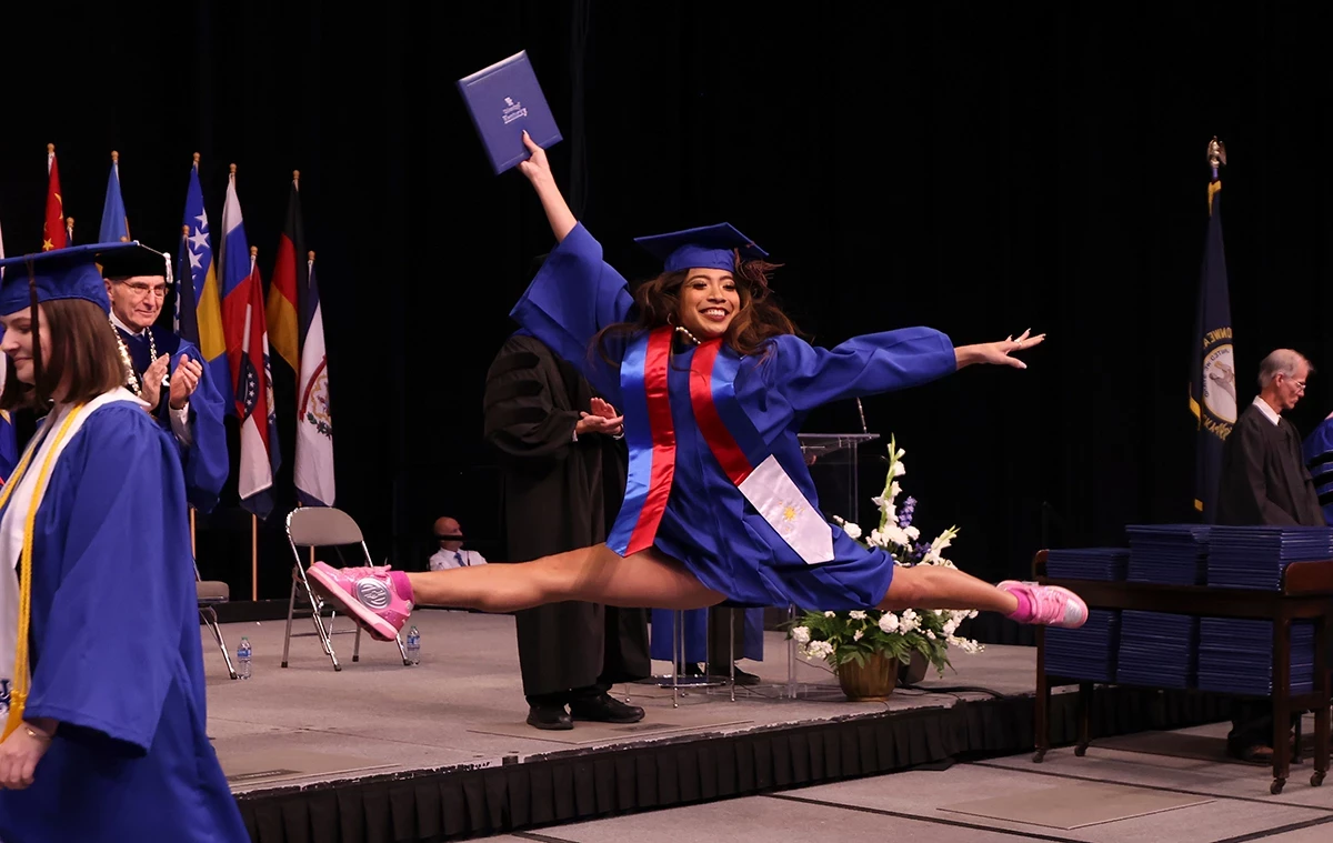 Student leaping in cap and gown