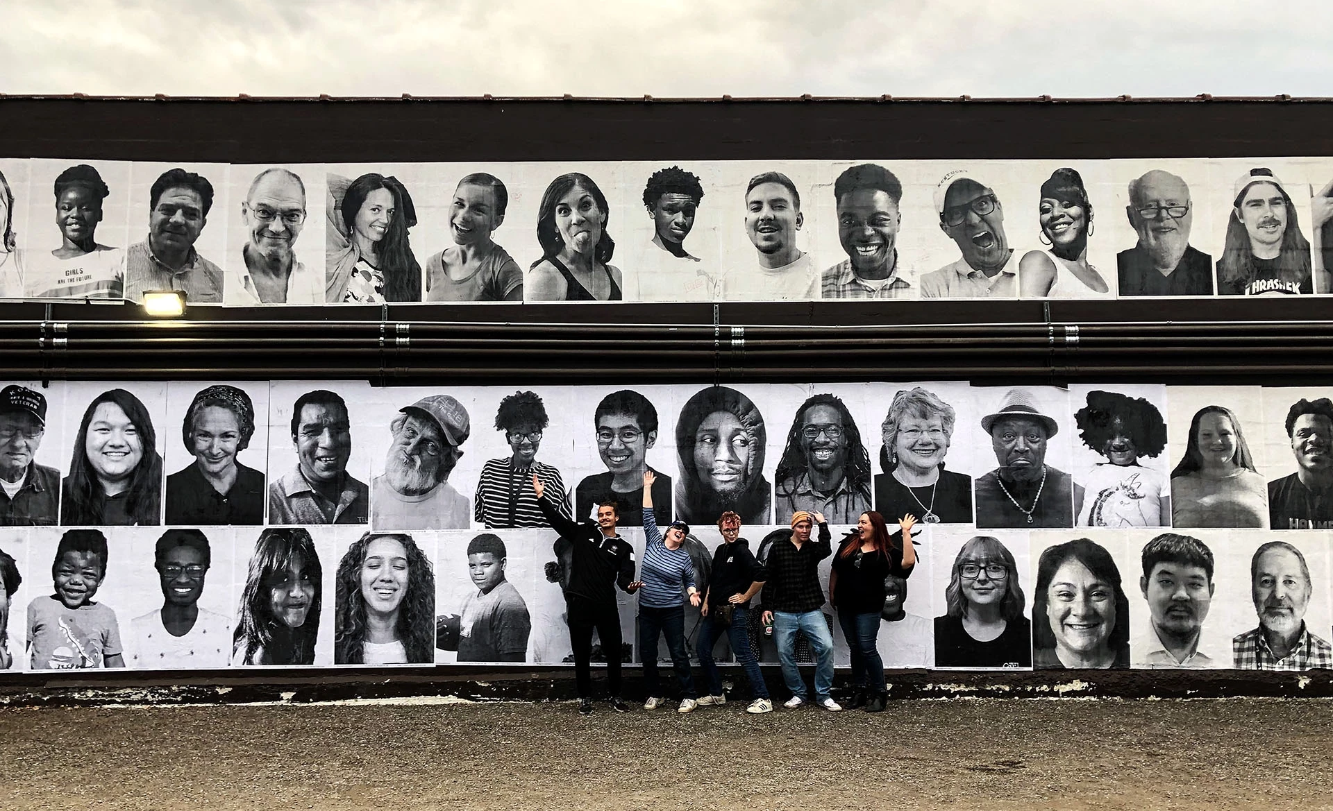 artists standing in front of a public mural