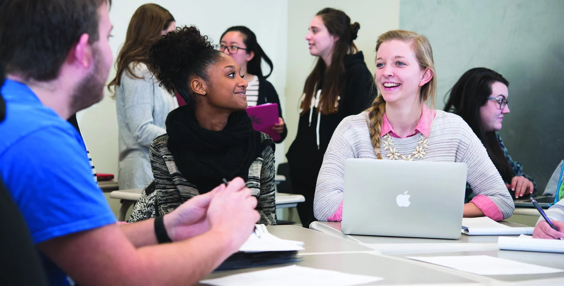 students talking at a table in a classroom