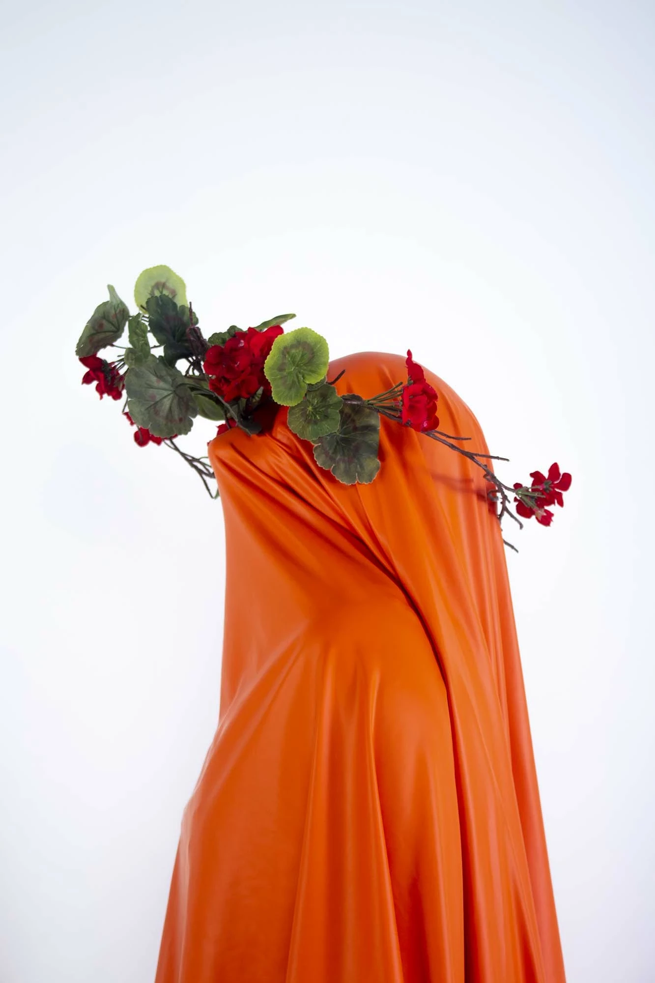 person under orange fabric with flowers