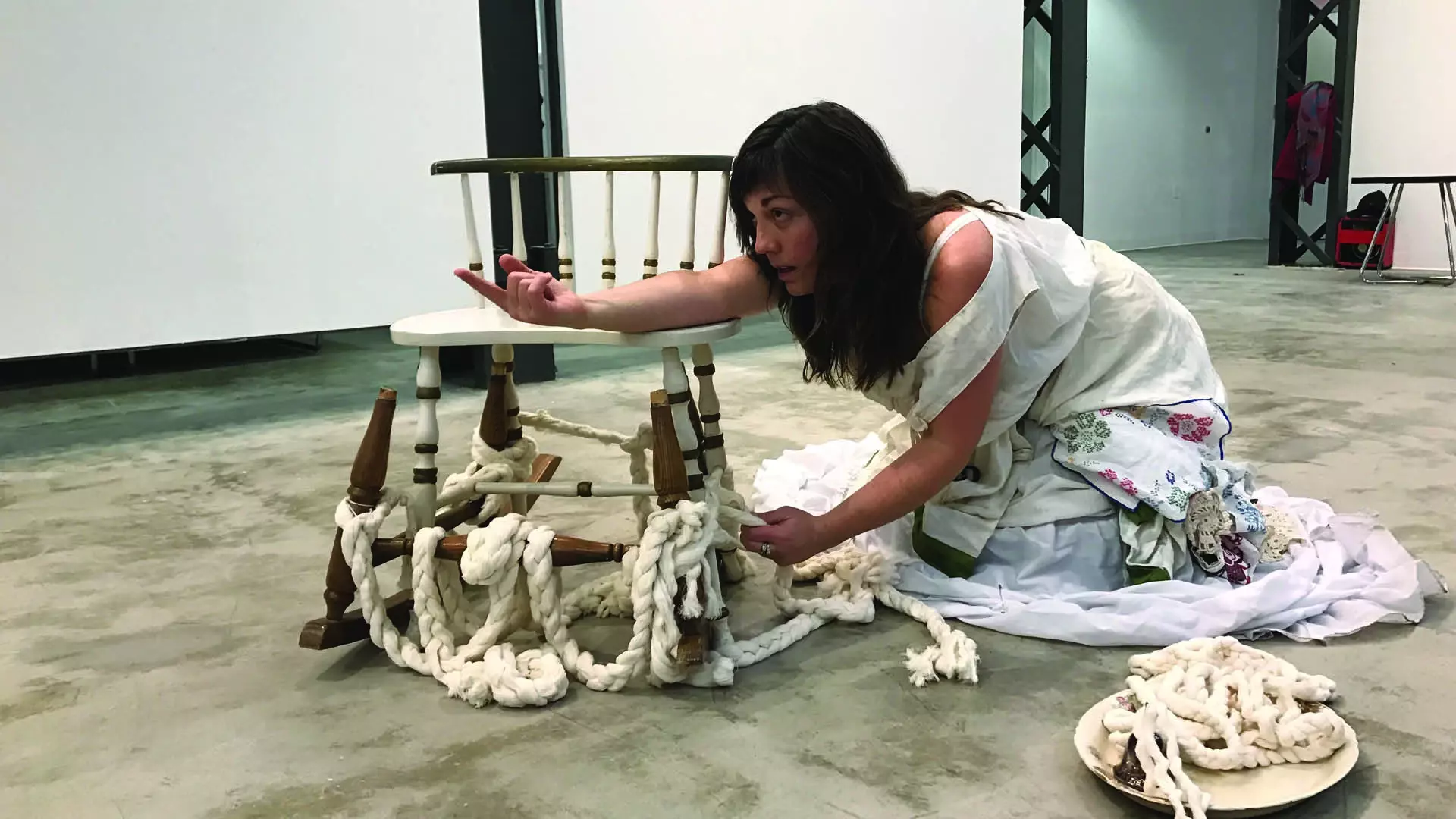 Performer on floor with chair and ropes