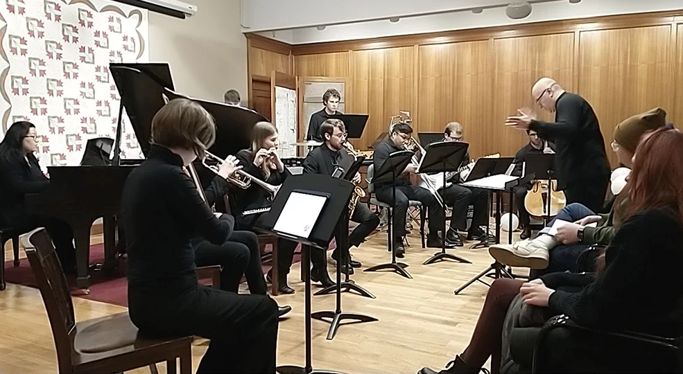 A diverse group of students with many different instruments performs in the John Jacob Niles Gallery.