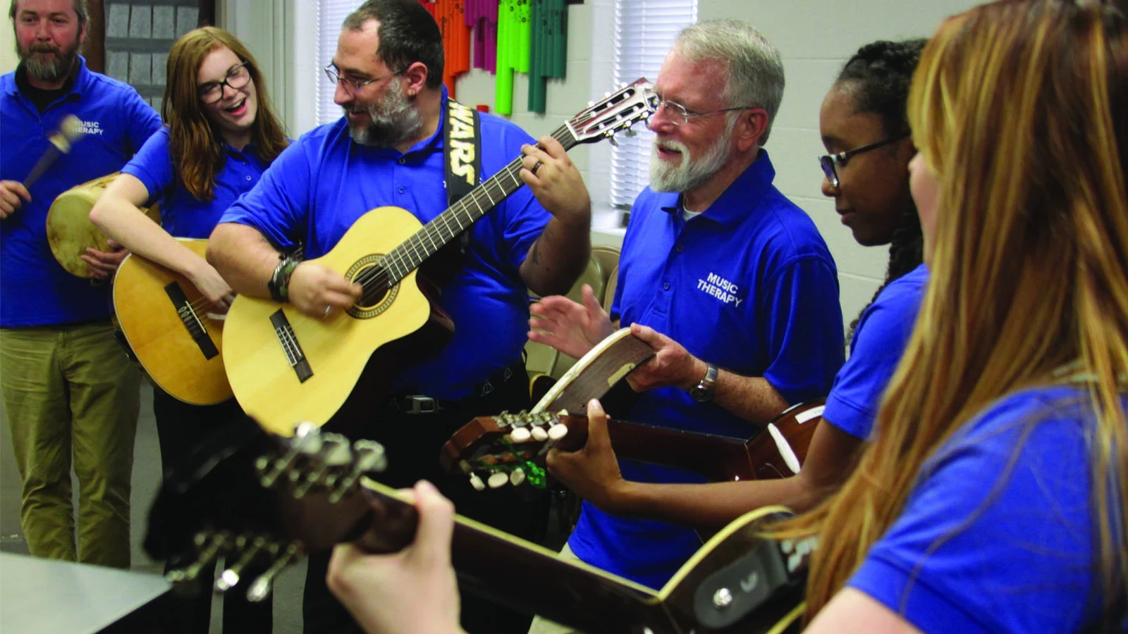 students in blue playing musical instruments