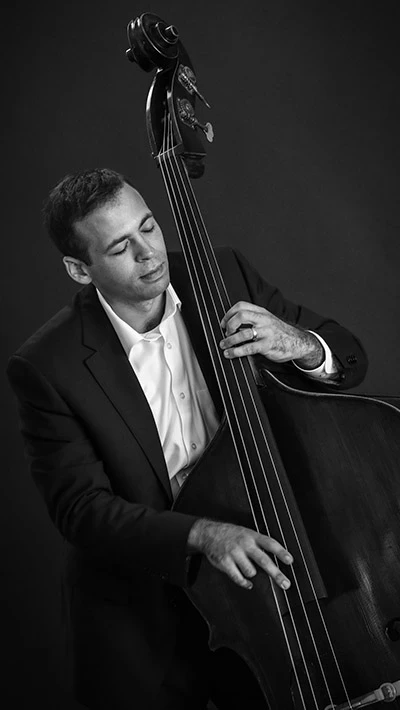 Headshot of Eli Uttal-Veroff playing an upright bass.