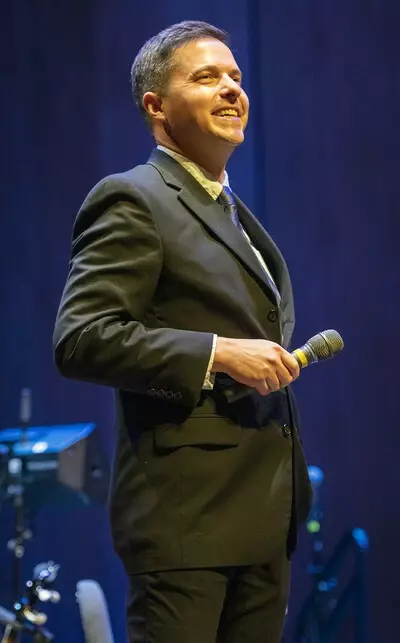 Matthew Gibson on stage holding a microphone