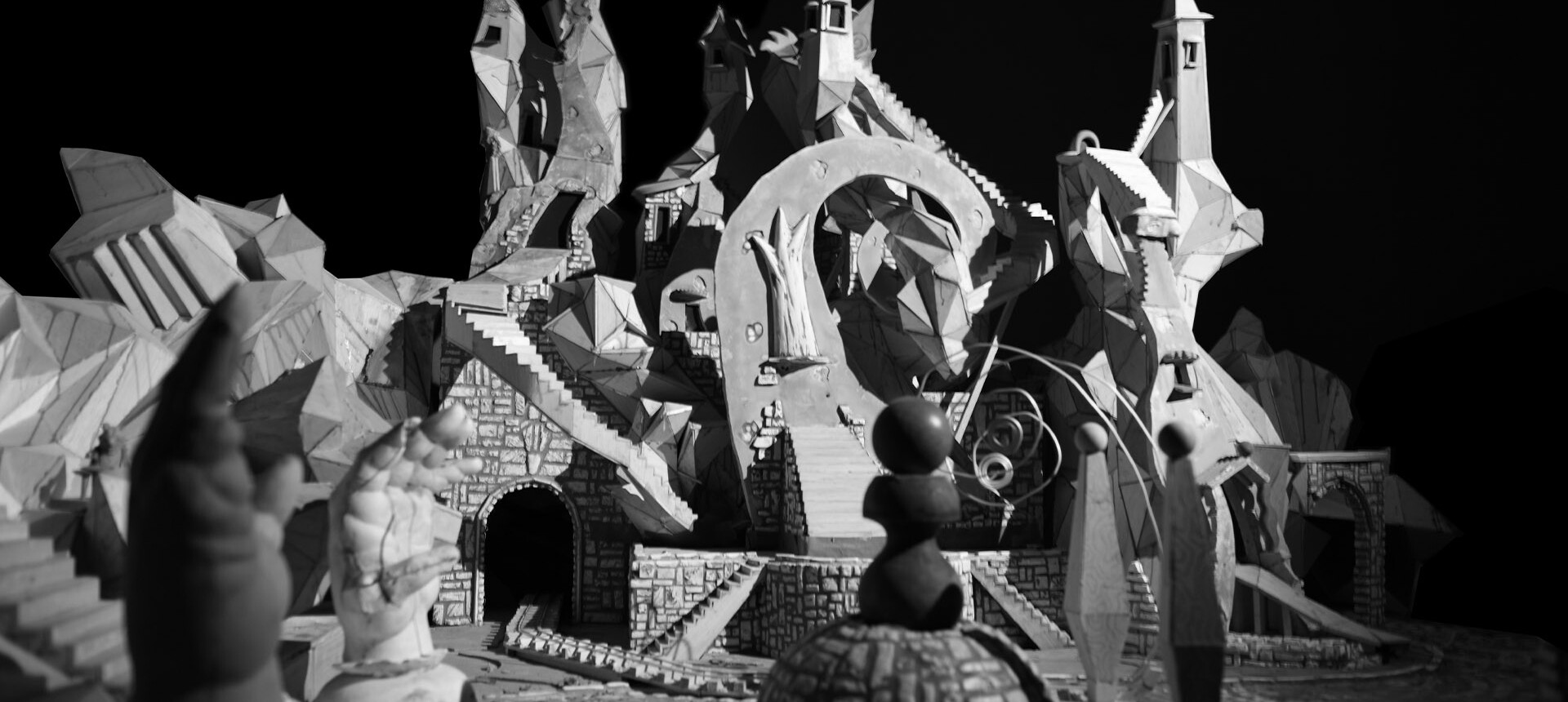 Detail view of Jay Bolotin, still image of the Carnival set. Black and white photograph of geometric, modernistic town square.