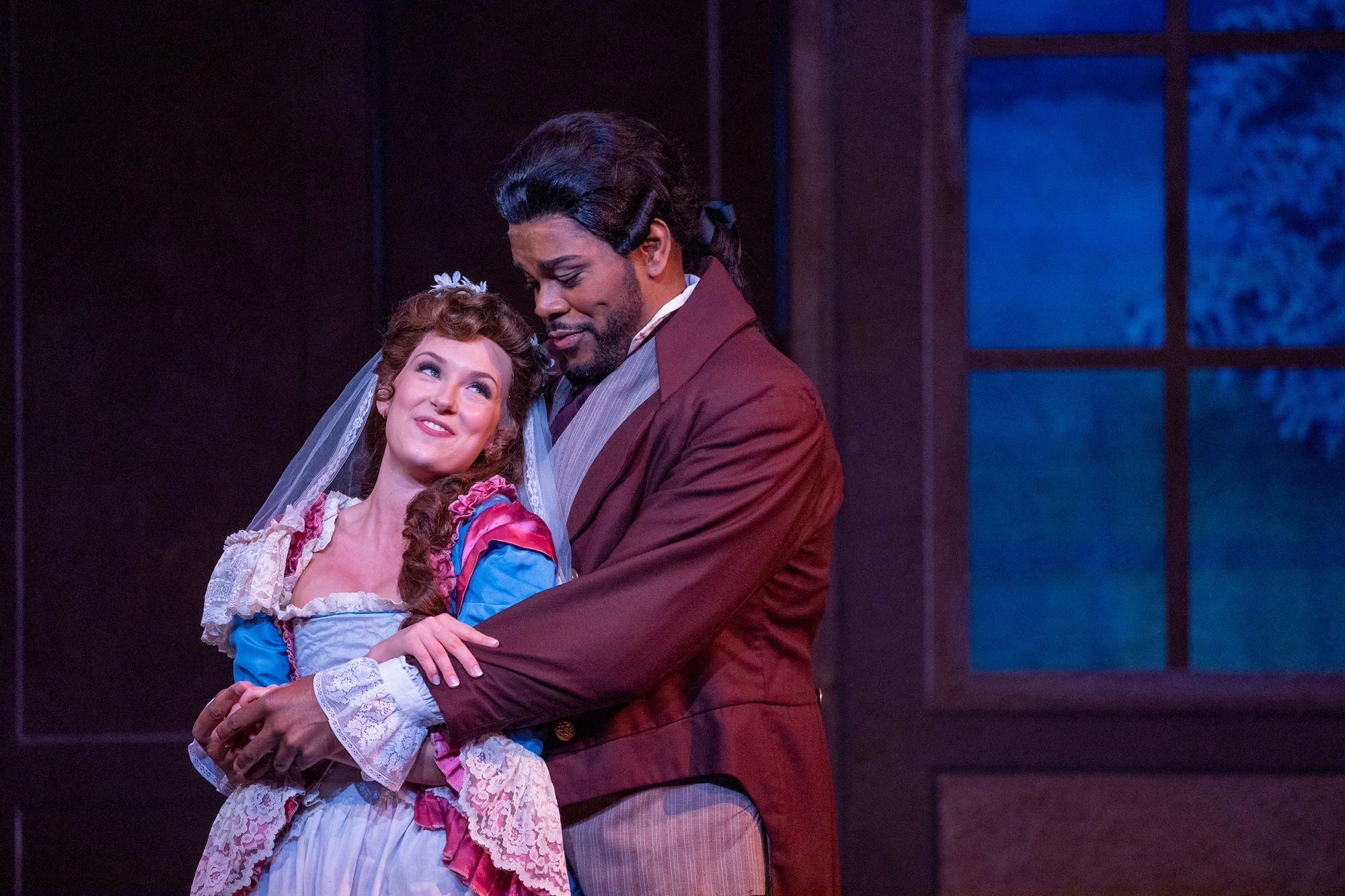 Close up of two performers on stage in an intimate pose during The Marriage of Figaro opera.
