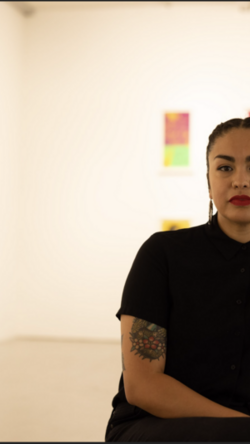 Person looking at camera with art in background