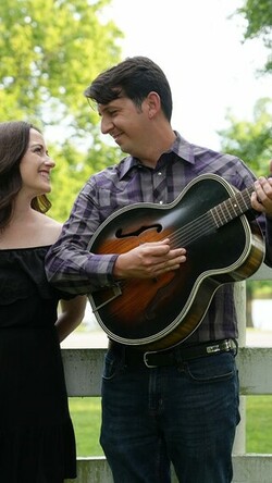 two people with guitar on farm