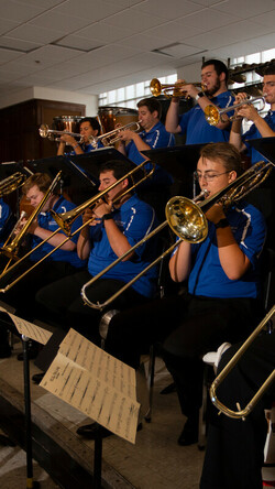 UK Lab Band members in blue polos playing brass instruments
