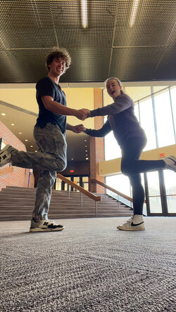 two students holding hands and dancing