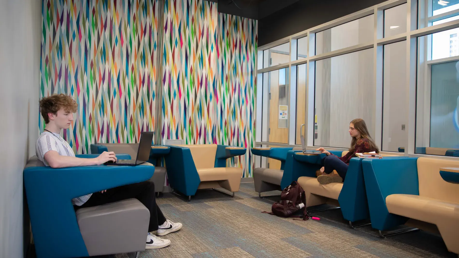 students working in room with colorful wallpaper