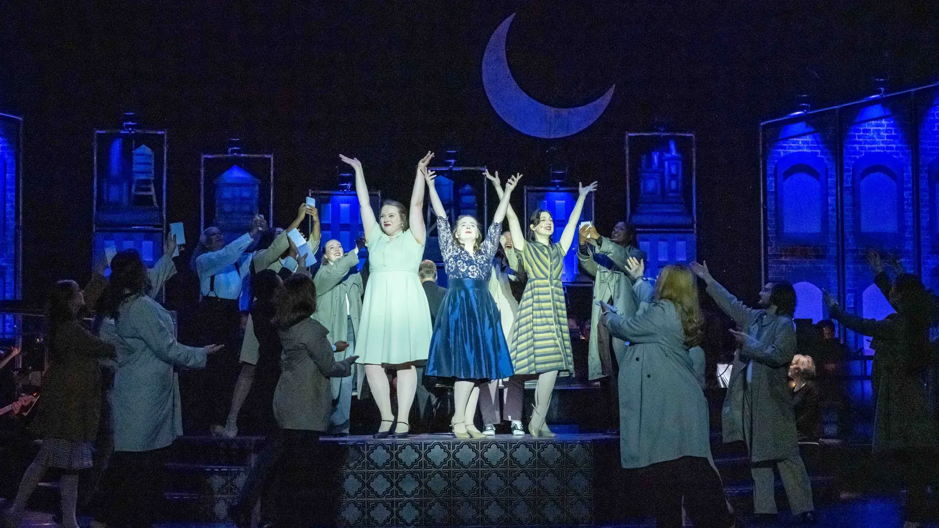 group of singers on stage, moon in scrim