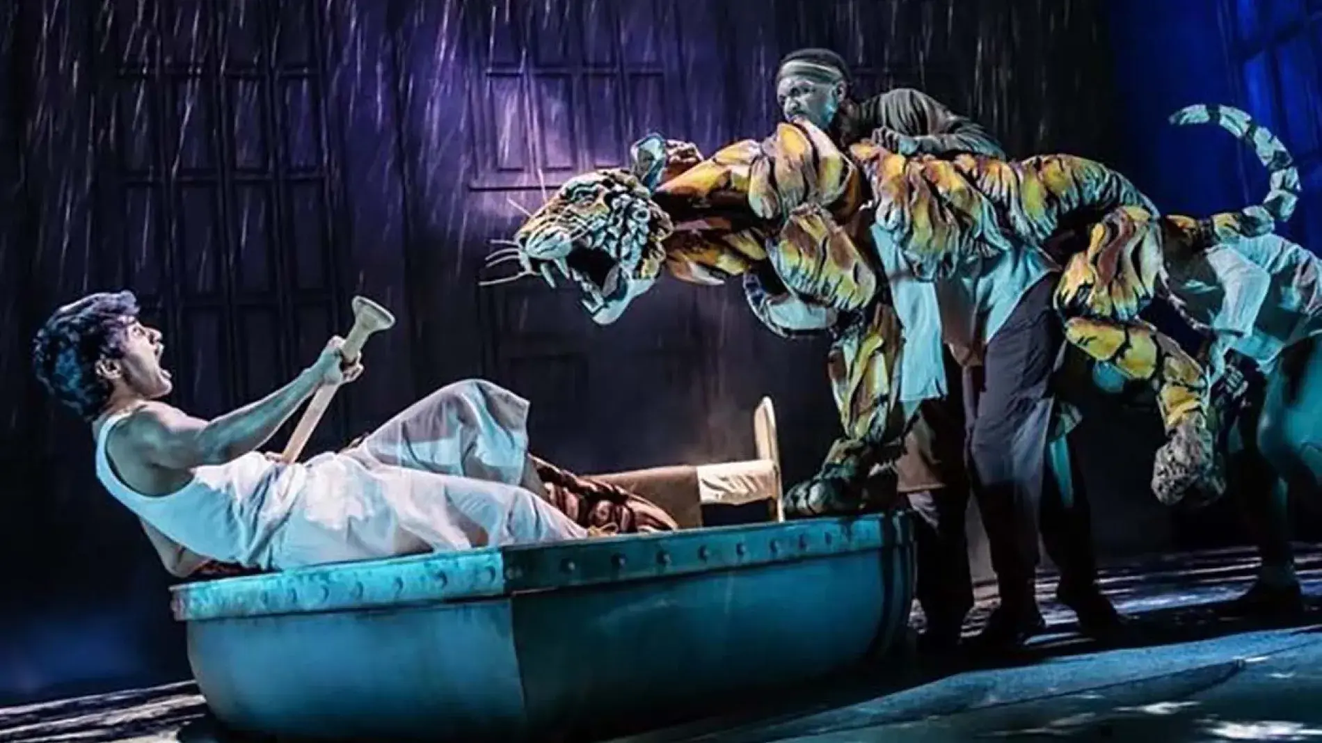 person on boat on stage with puppet tiger