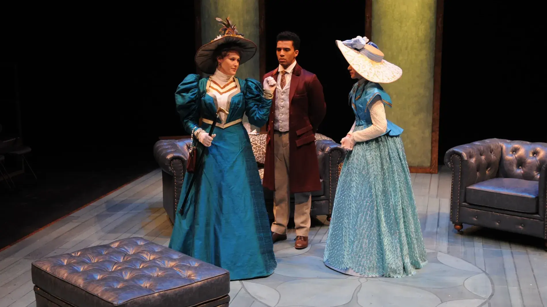 three actors on stage in period costumes