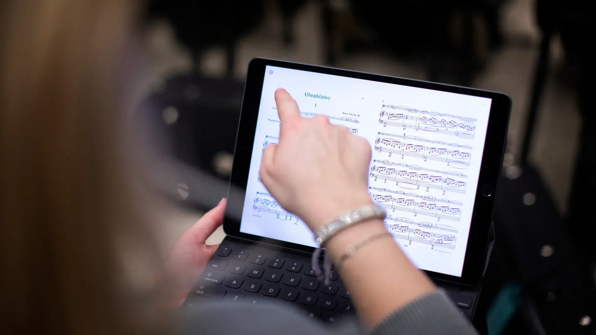 student pointing to music on ipad