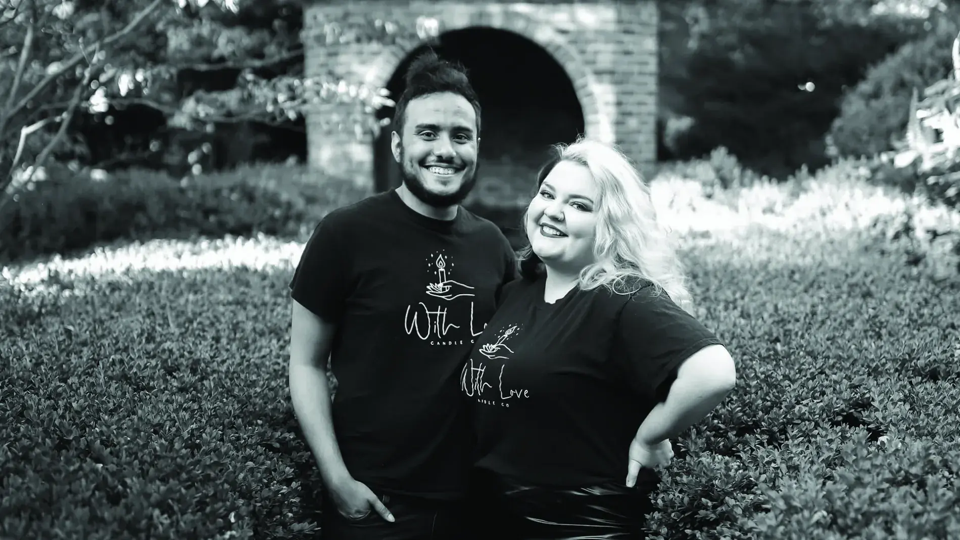 Tommy Townsend and Alexandra Burns post together wearing tshirts with the With Love business logo, black and white photo