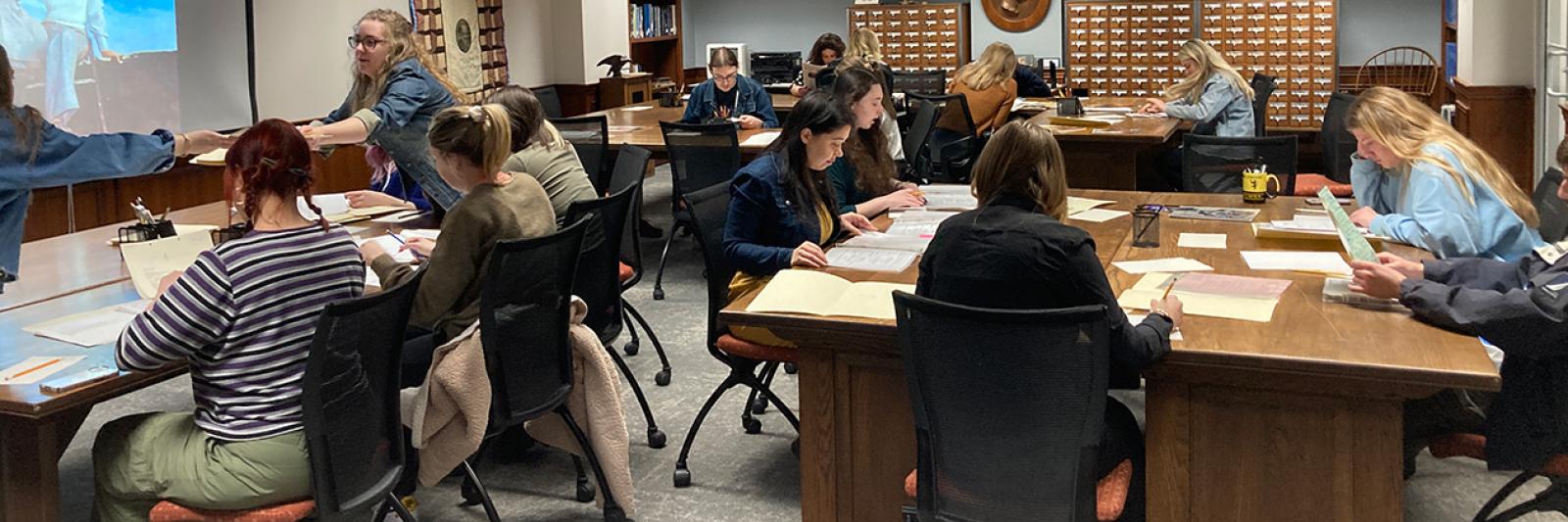 Students sit around tables at the Berea Archives looking at articles and papers