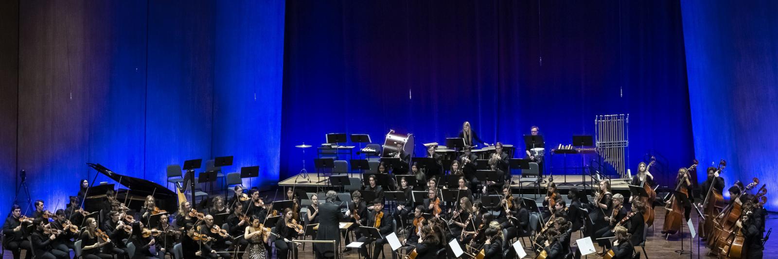 SYMPHONY ORCHESTRA ON STAGE IN BLUE LIGHTS