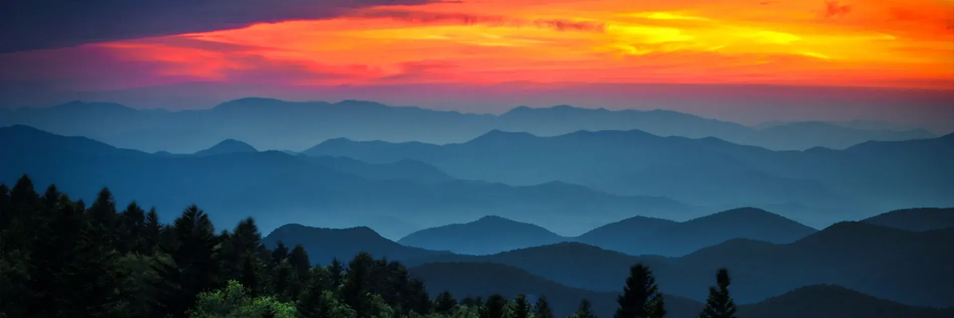 Digitally enhanced image of a sunset sky and mountains in the foreground