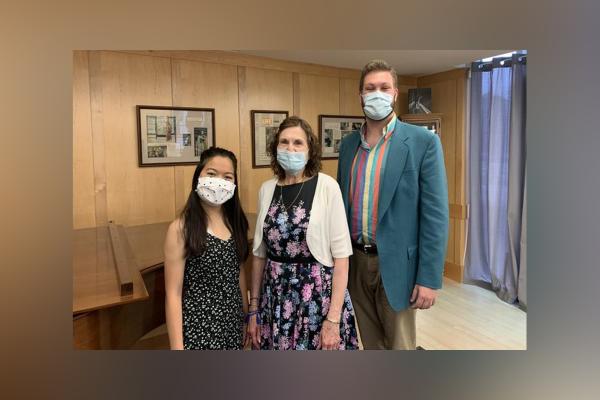 Image of three people wearing face masks posing inside a music studio