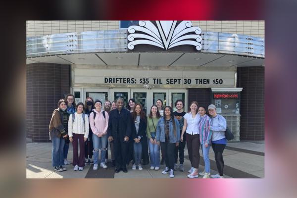 Image of students gathered outside in front of the Lyric Theatre's marquee, during the daytime