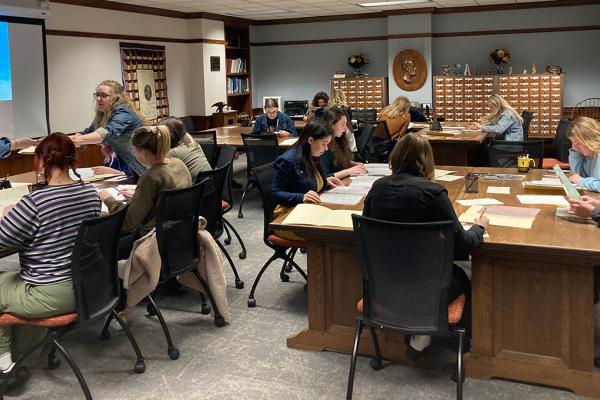 Students sit around tables at the Berea Archives looking at articles and papers